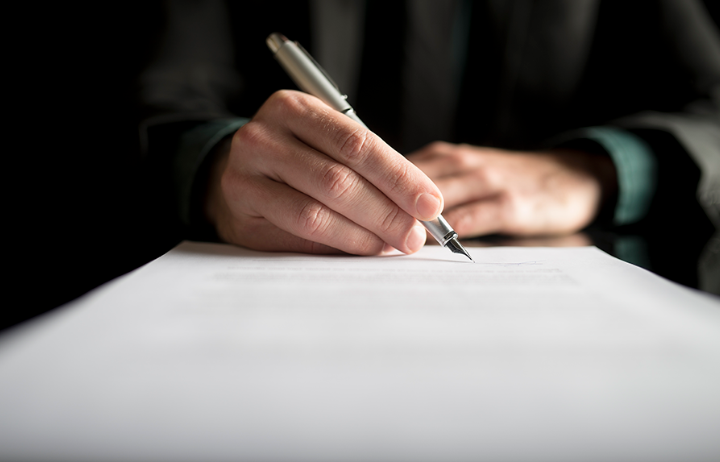 closeup-of-lawyer-or-executive-signing-a-contract-JCSOLUTIONS